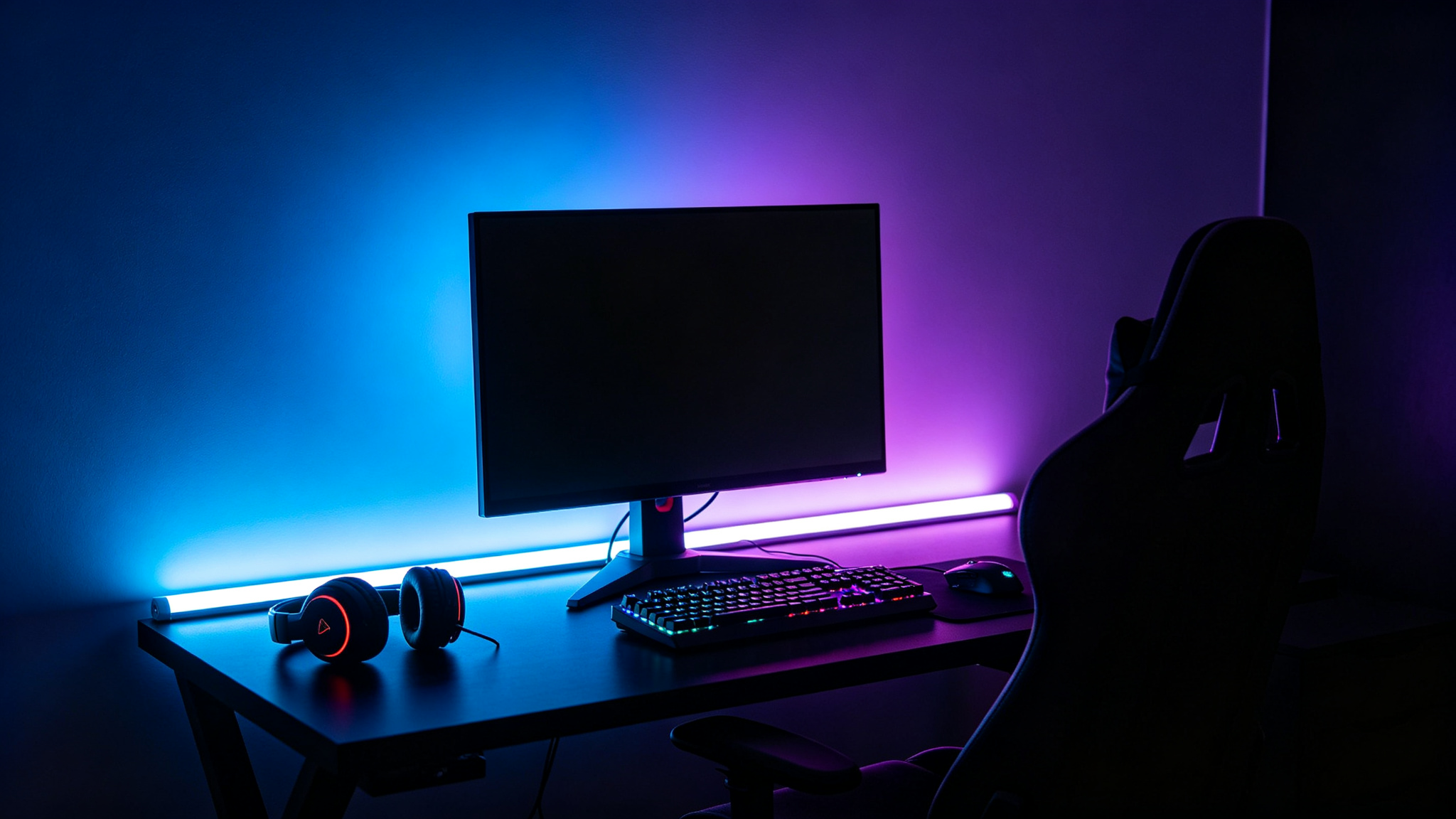Gaming desk with RGB bias strip casting blue-purple ambient glow