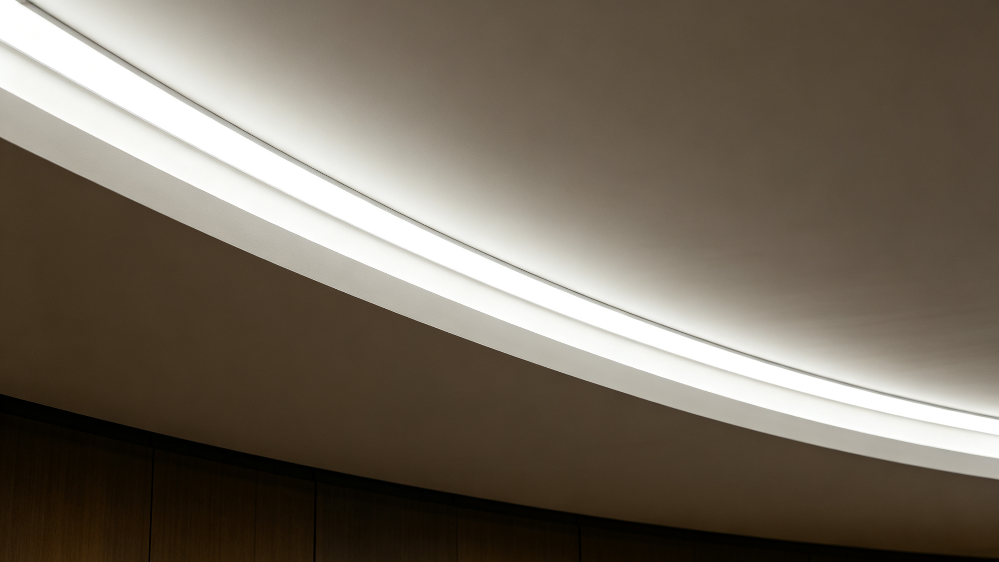 Long continuous LED strip along a curved lobby cove with seamless uniform glow