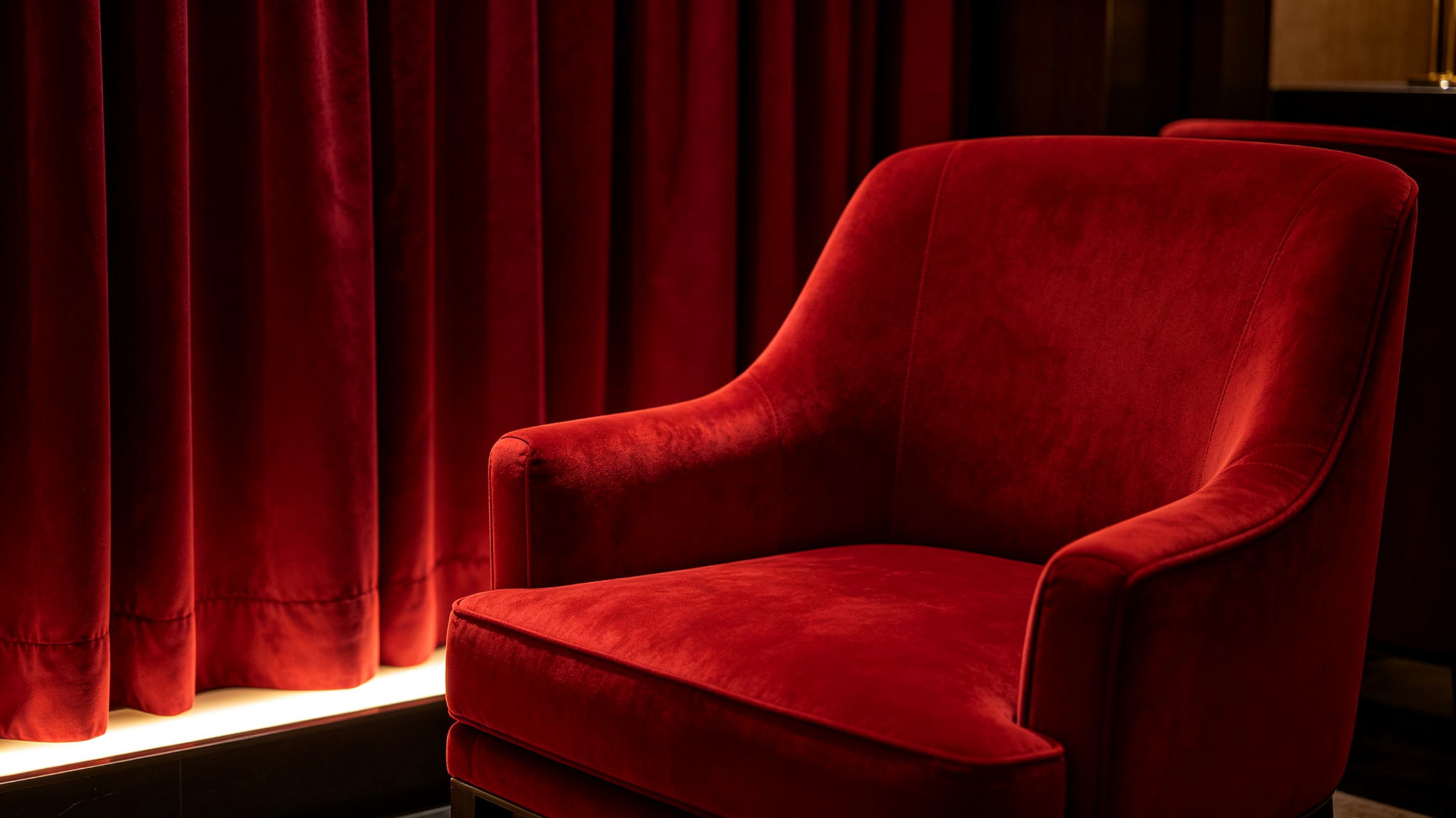 Deep red velvet armchair and burgundy drapery lit accurately by a high-R9 LED cove