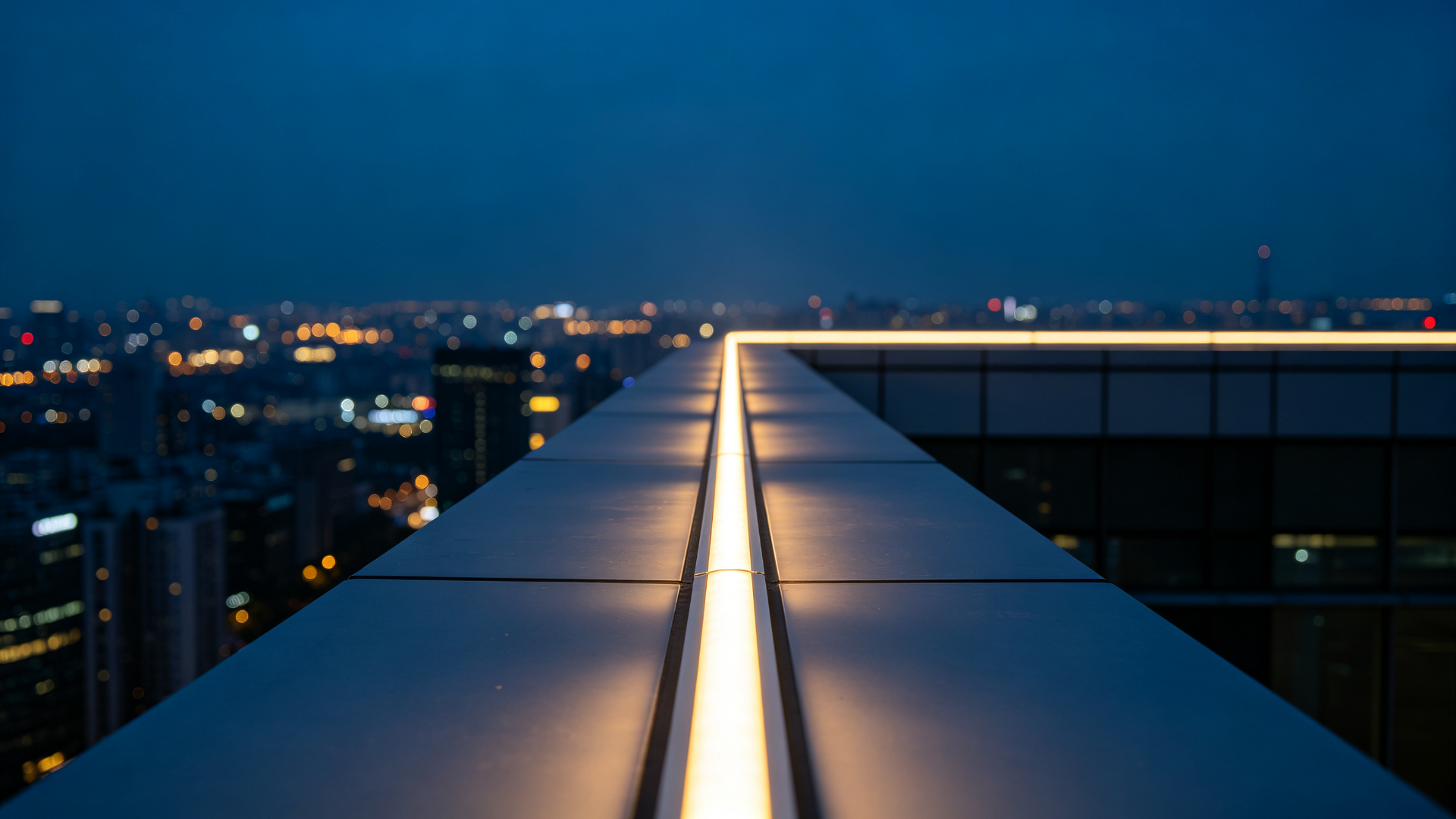 Continuous warm white LED line along a rooftop parapet maintaining perfectly even brightness over a very long run
