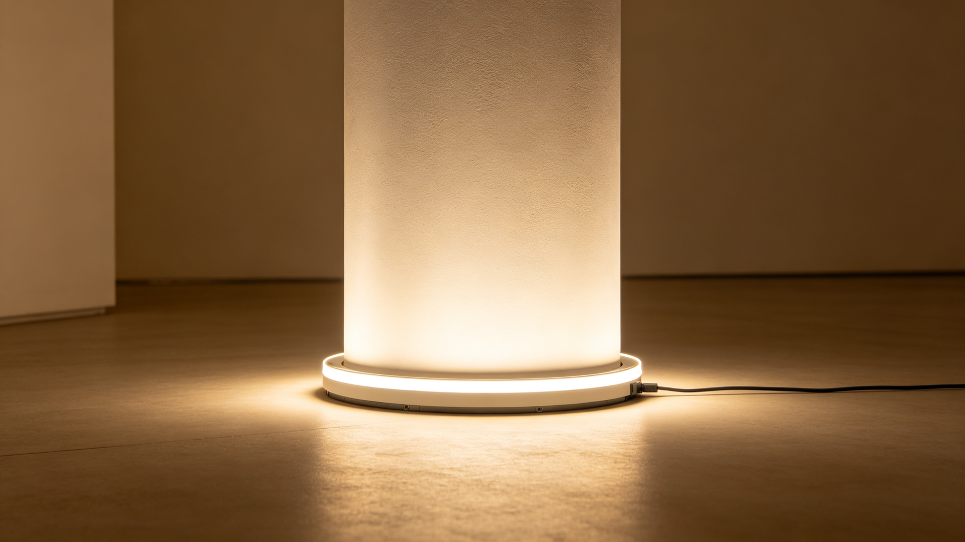 Top-bend LED wall washer strip at the base of a smooth plaster column washing light upward