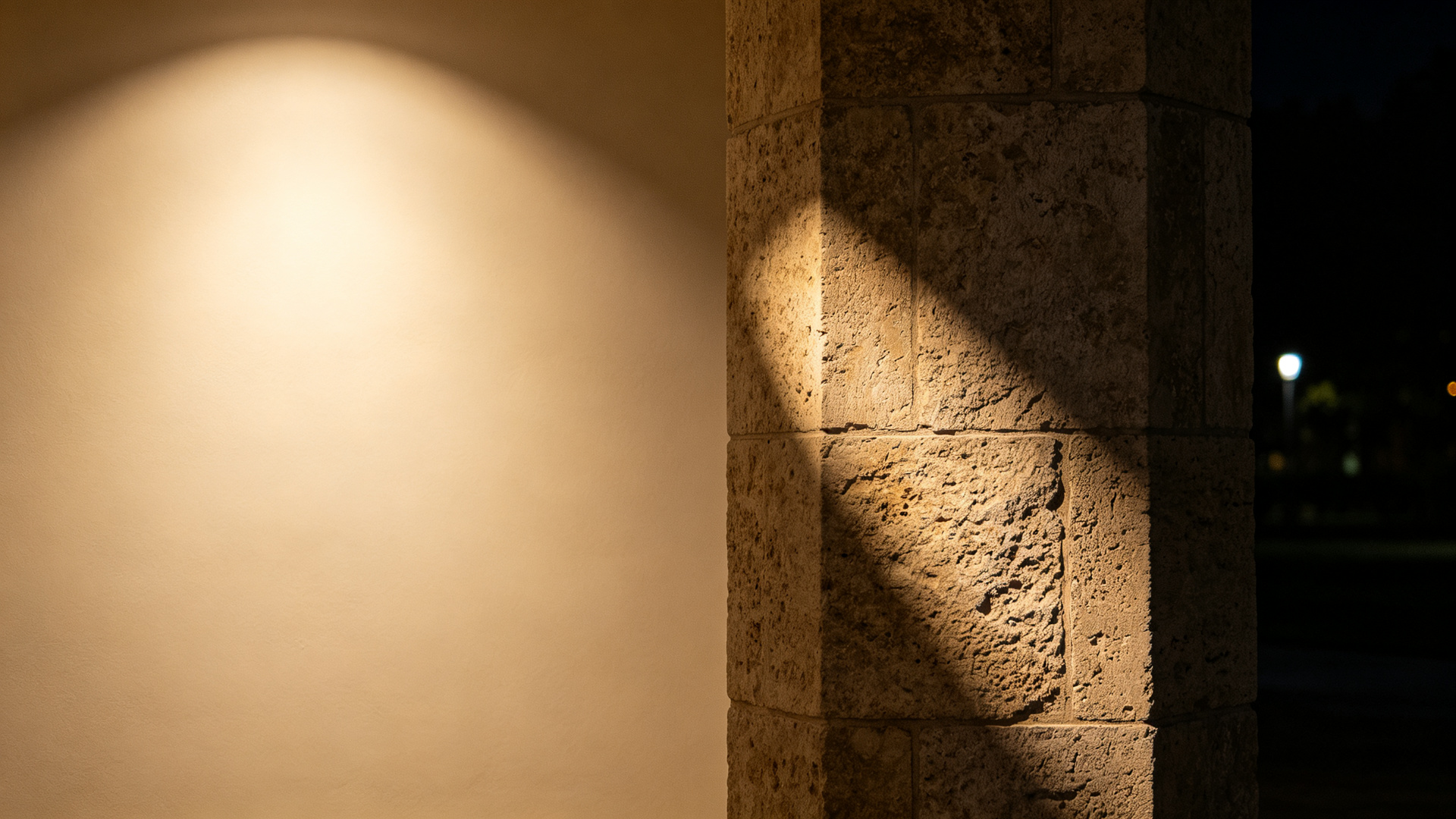 Split comparison: smooth uniform wall wash on plaster versus textured grazing shadows on stone