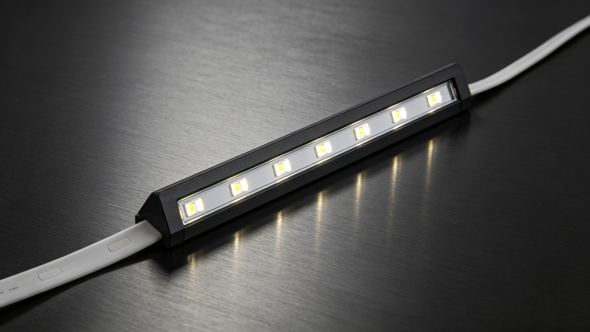 Flexible silicone LED wall washer strip with asymmetric optics on a dark studio surface